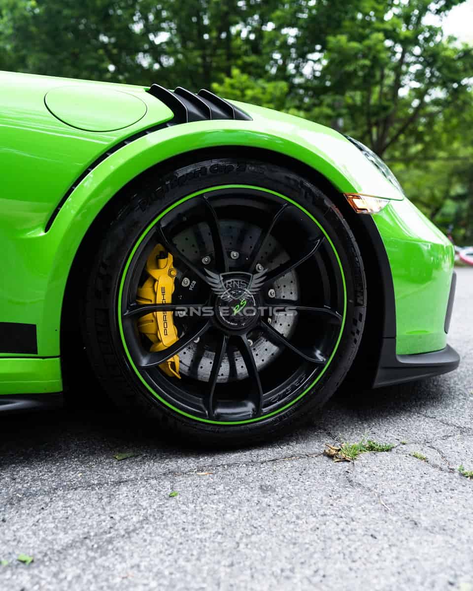 Bright green sports car with black sport rims and racing tires